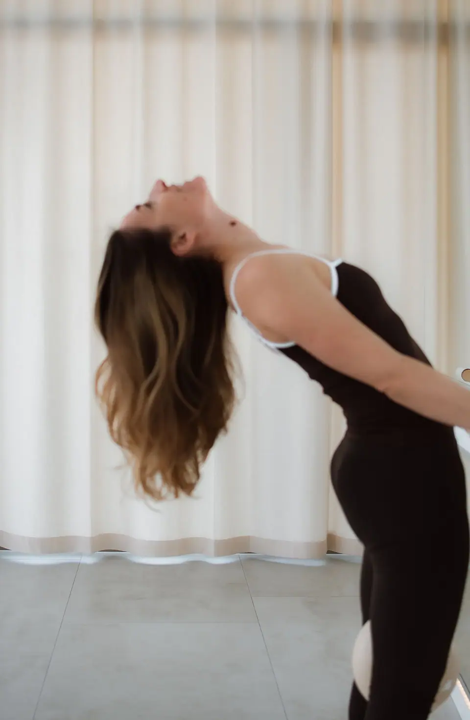 Anastasija Berg hält sich an der Ballettstange und lässt sich mit offenem Haar weit nach hinten fallen