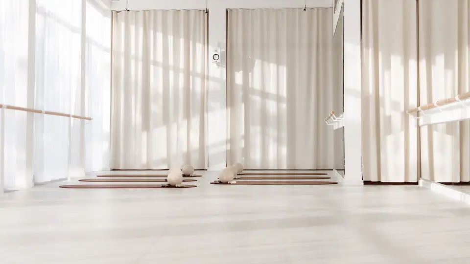 Heller Pilates- und Barre-Raum mit Vorhängen und Matten, MÉ·US Studio Heidelberg