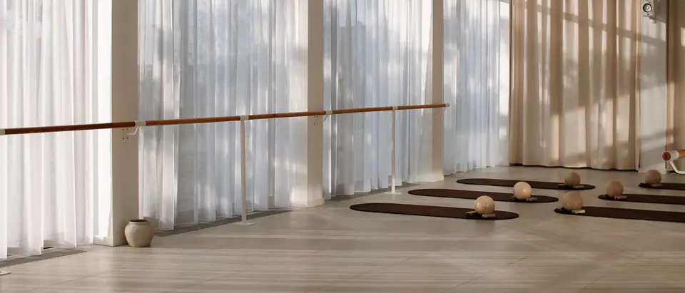 Der große Trainingsraum von MÉ·US mit Fensterfront, Ballettstange und Matten in der Bahnstadt