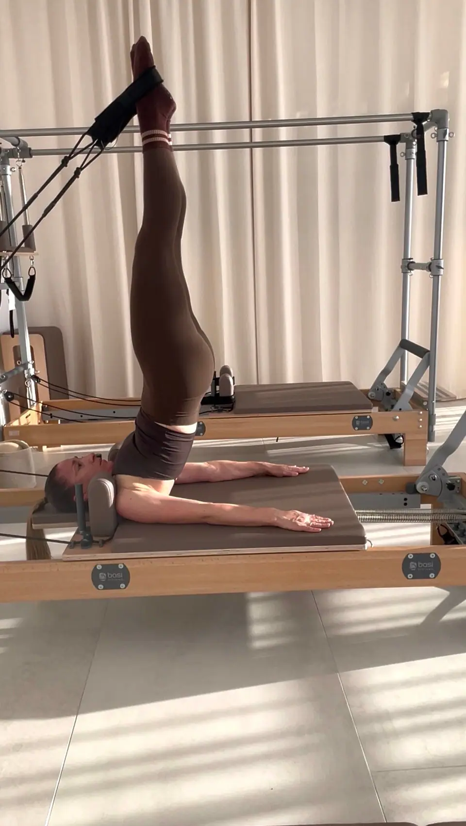 Short Spine am Reformer mit Tower, die Beine in den Schlaufen, MÉ·US Studio Heidelberg